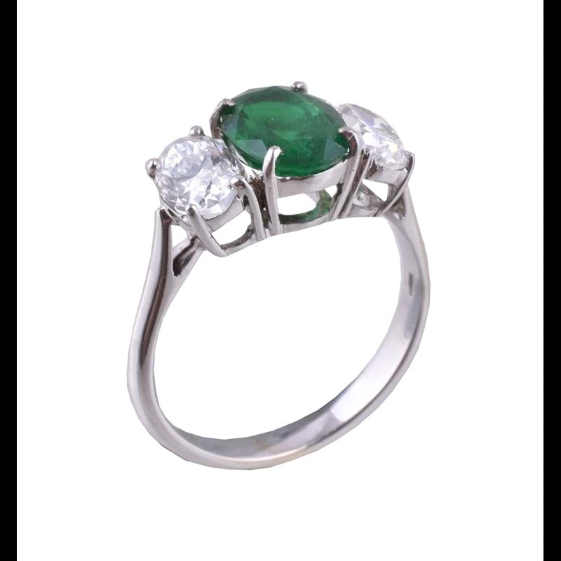 An emerald and diamond three stone ring 