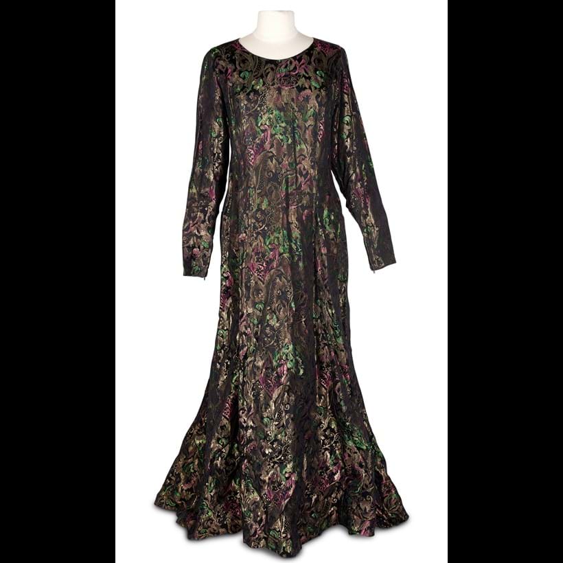 Inline Image - An evening dress in gilt metal brocade shot with emerald green and pink on a black ground,  mid 20th century | £80-100 (+ fees)