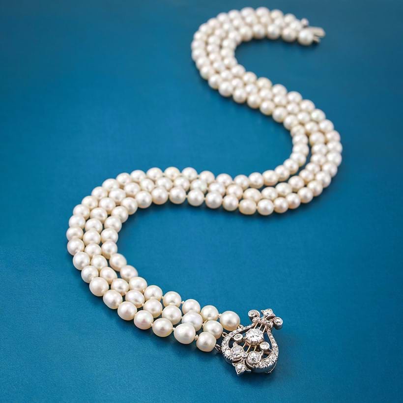 Inline Image - Lot 97: A three strand natural pearl necklace with late 19th century and later diamond clasp | Sold for £56,450