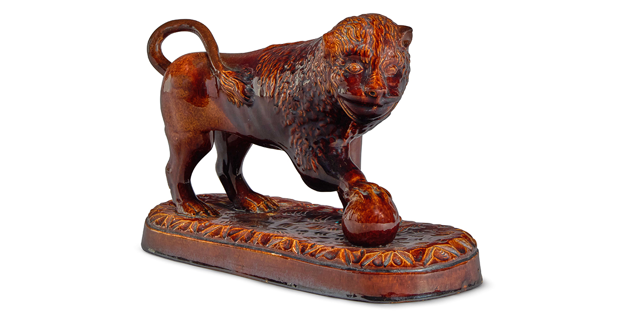 Sibyl Colefax & John Fowler auction - Lot 111 - A treacle-glazed pottery model of a Medici lion.jpg