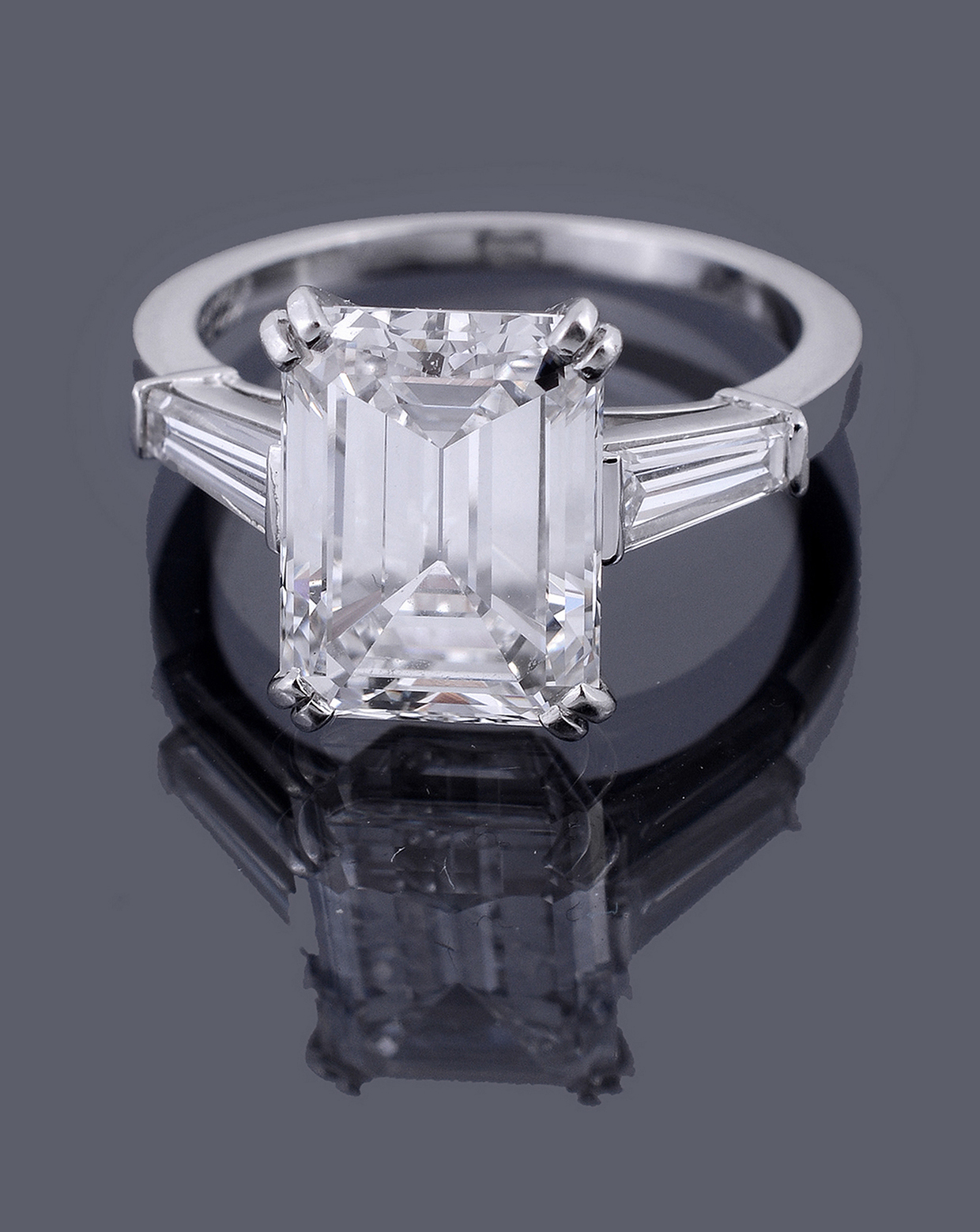 A single stone diamond ring by Van Cleef and Arpels, the step cut diamond with canted corners weighing 4.73 carats.jpg
