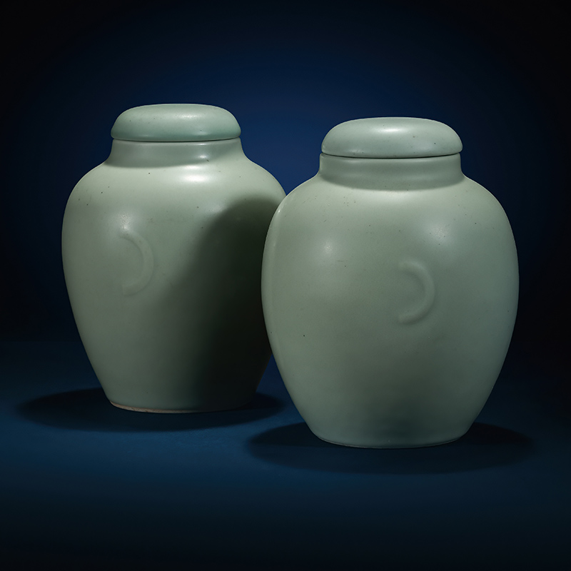 A rare pair of Chinese celadon-glazed jars and covers, Qianlong seal mark and of the period (1736-1795)