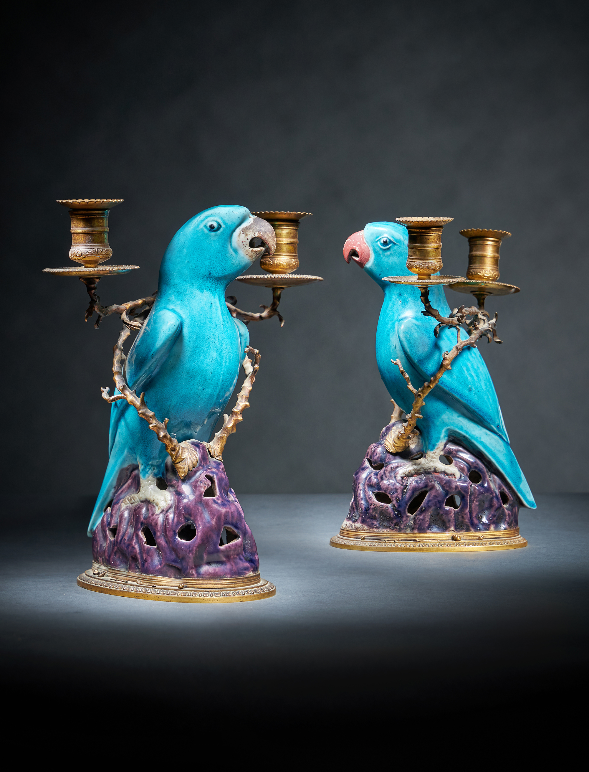 A fine pair of Chinese gilt-metal mounted biscuit porcelain parrot candelabra, the porcelain Kangxi (1662-1722)