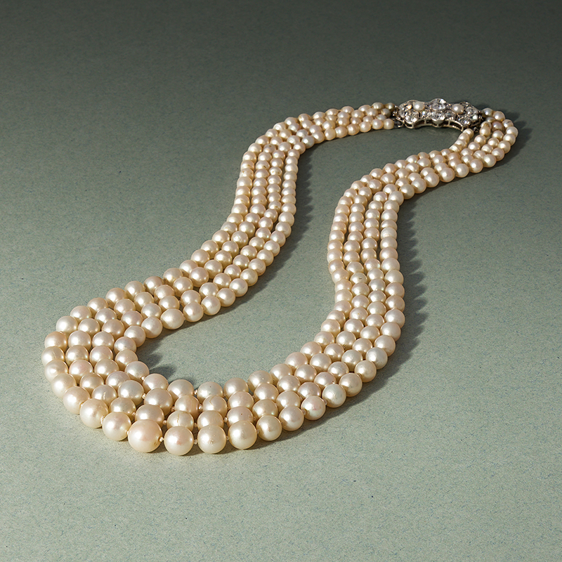 An early 20th century four row natural pearl and diamond necklace