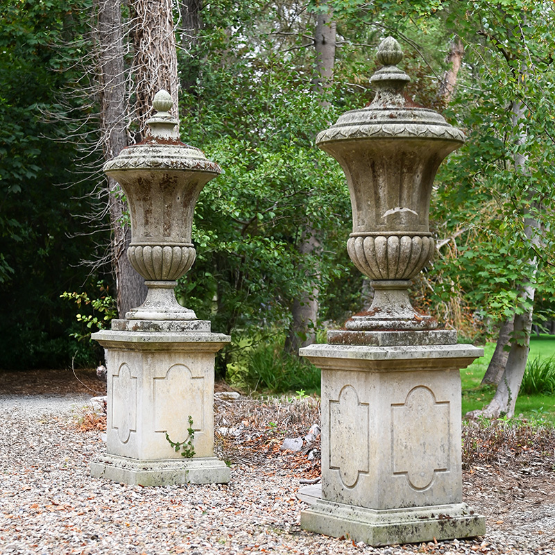A monumental pair of Italian limestone urn finials on pedestals, 20th century